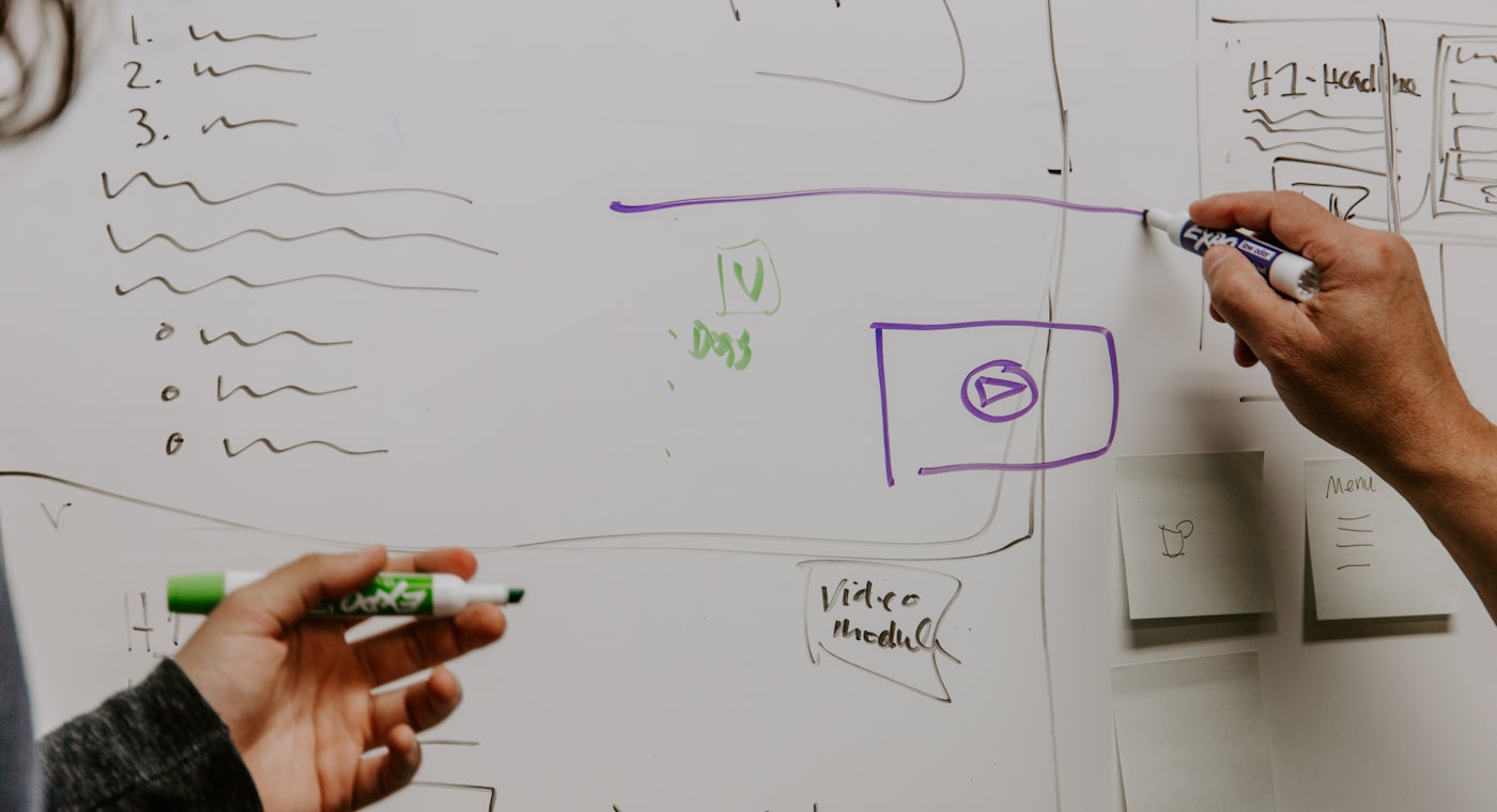 Equipe comercial reunida planejando o processo de vendas em uma sala com quadro branco